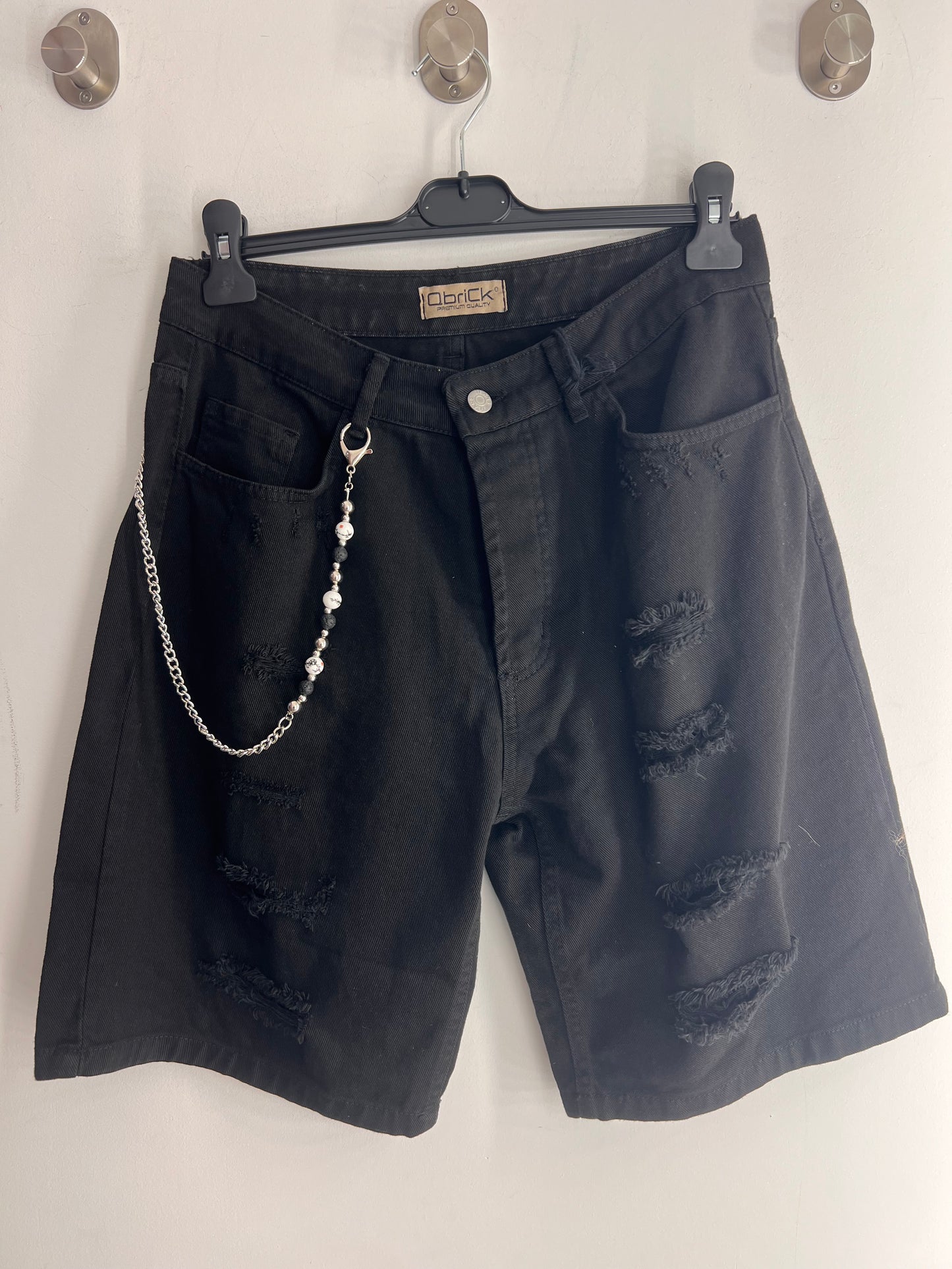 jeans corto skinny nero strappato con catena